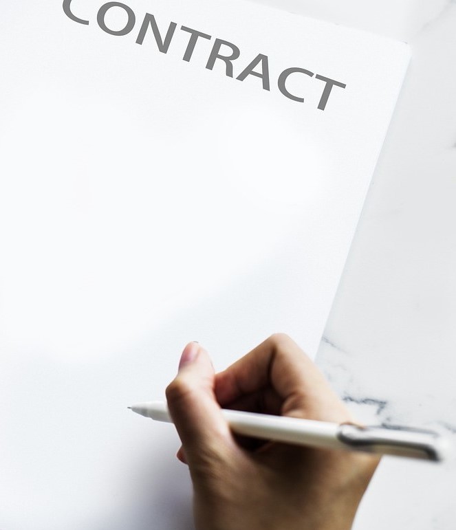 A hand signing a contract