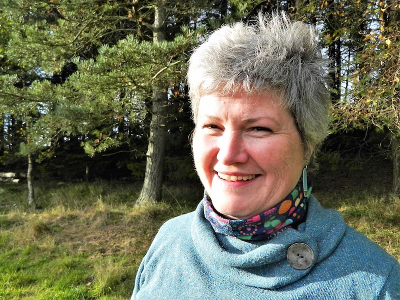 Jean Nairn standing next to a wood